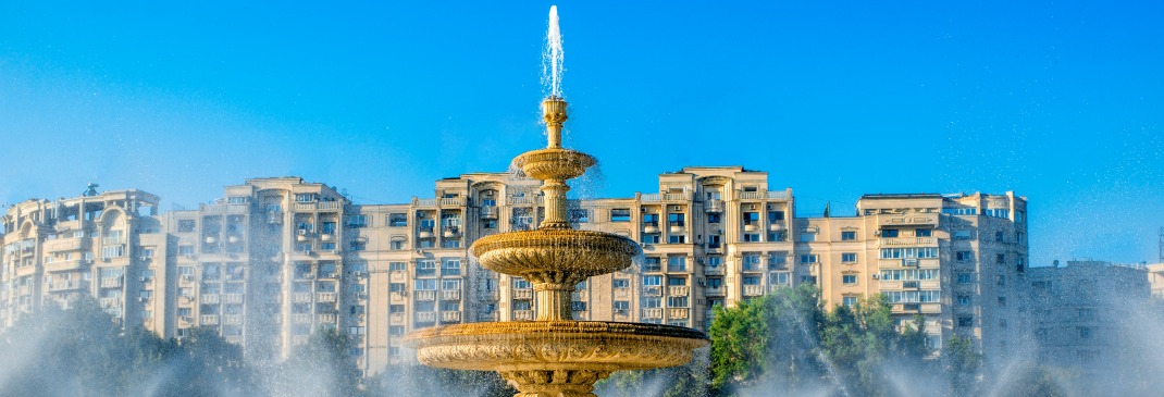 Water sprays out of the large gold fountain in the heart of Bucharest